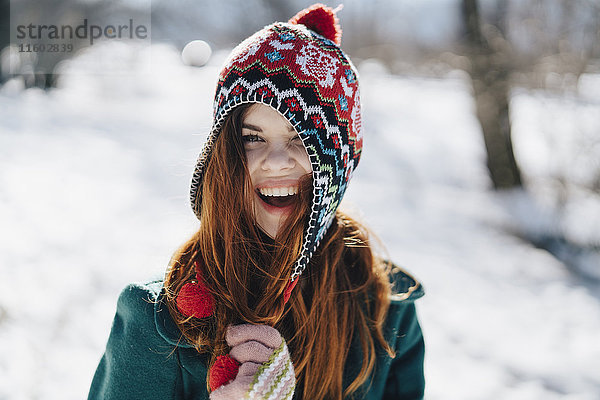 Kaukasische Frau spielt mit Hut im Winter