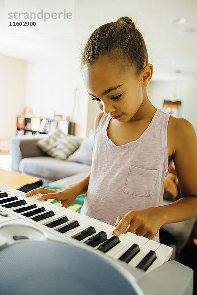 Mixed Race Mädchen spielt Musik auf dem Keyboard