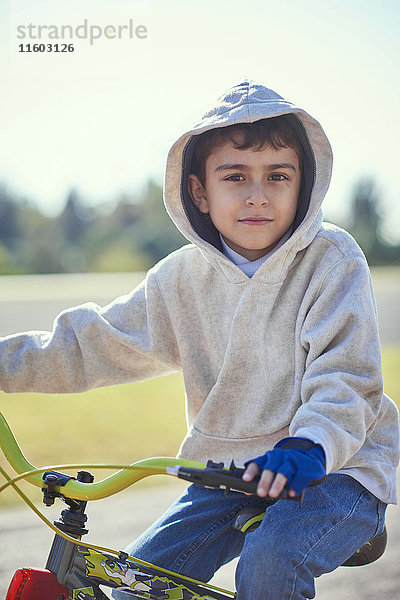 Hispanischer Junge posiert auf dem Fahrrad