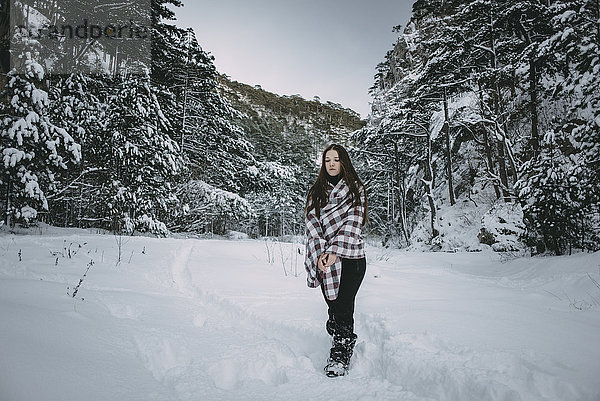 Kaukasische Frau in Decke eingewickelt im verschneiten Wald