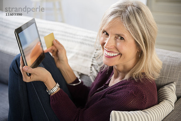 Lächelnde kaukasische Frau beim Online-Shopping mit digitalem Tablet