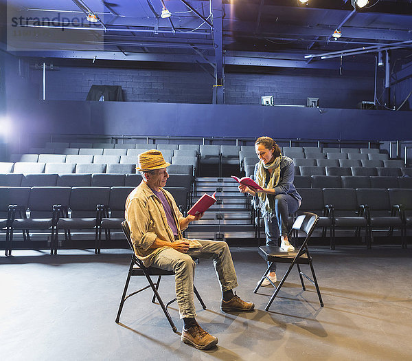 Kaukasische Schauspieler proben mit Drehbüchern im Theater