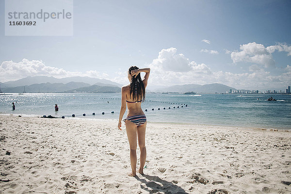 Kaukasische Frau trägt Bikini am Strand