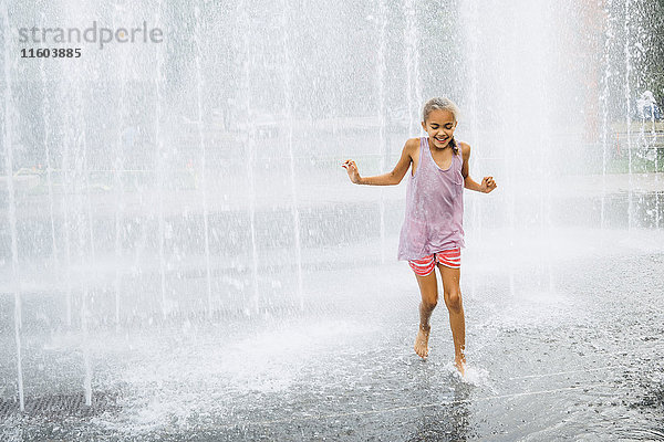 Lächelndes Mixed Race Mädchen läuft Brunnen