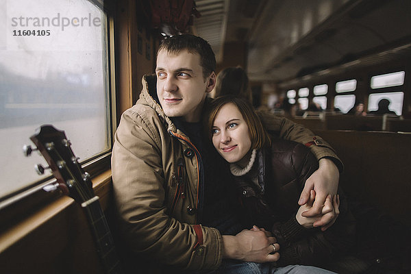 Kaukasisches Paar umarmt sich im Zug