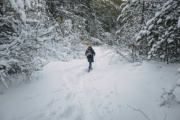 Kaukasische Frau beim Wandern im verschneiten Wald