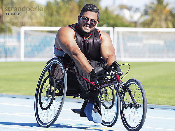 Mann aus dem Nahen Osten fährt im Rollstuhl auf der Rennstrecke