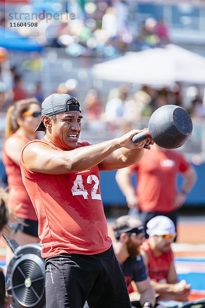 Mann hebt Kettlebell im Freien