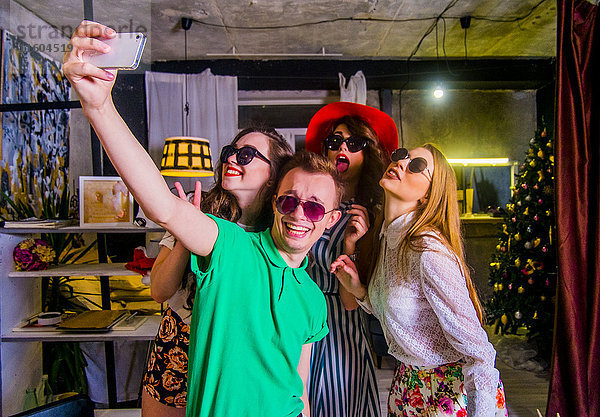Modische kaukasische Freunde  die für ein Handy-Selfie posieren