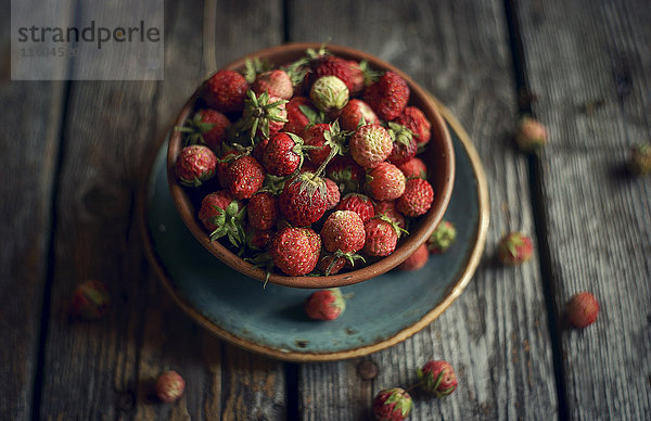 Schale mit roten Erdbeeren auf Holztisch