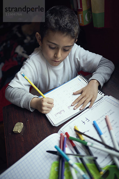 Hispanischer Junge übt das Schreiben des Alphabets