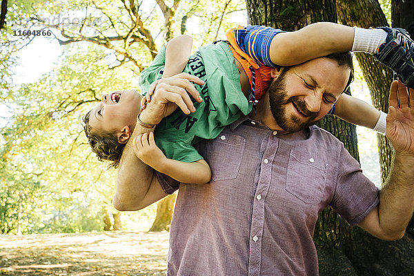 Kaukasischer Vater spielt mit seinem Sohn auf der Schulter