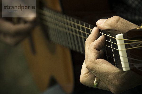 Hände auf dem Mann  der Gitarre spielt