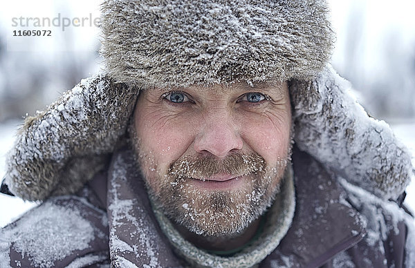 Porträt eines kaukasischen Mannes mit Eis im Bären im Winter