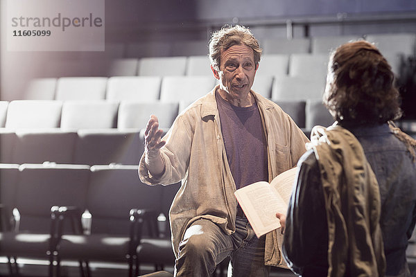 Kaukasische Schauspieler proben mit einem Drehbuch im Theater