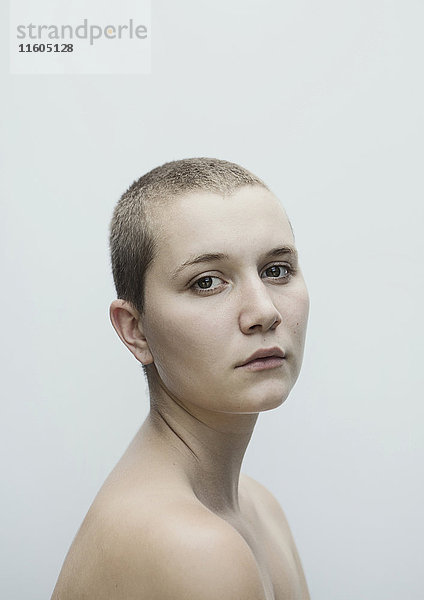 Porträt einer ernsten kaukasischen Frau mit rasiertem Kopf