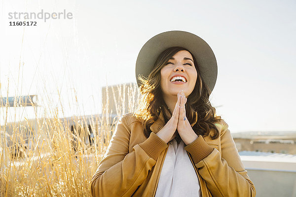 Porträt einer lächelnden gemischtrassigen Frau  die betet