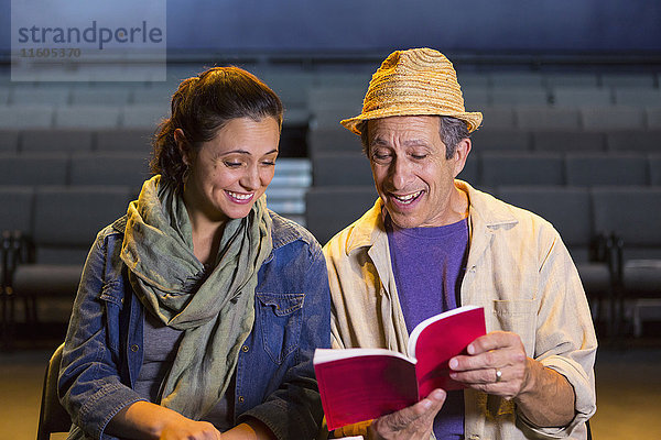 Kaukasische Schauspieler proben mit einem Drehbuch im Theater