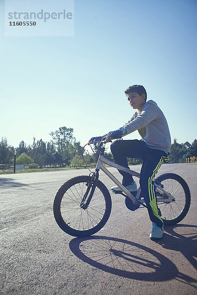 Ernster hispanischer Junge auf Fahrrad