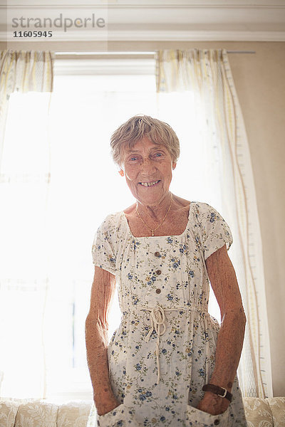 Porträt einer glücklichen Seniorin beim Schleifen im hell erleuchteten Haus