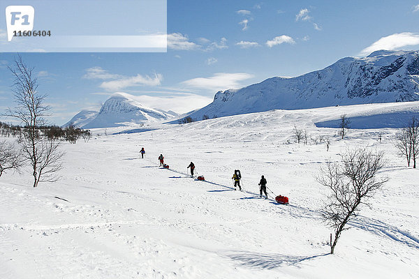 Touristen beim Skilanglauf vor Bergkulisse