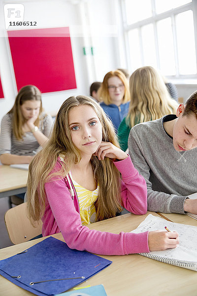 Teenager-Mädchen schaut in die Kamera im Klassenzimmer