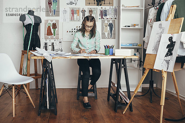 Schöne Designerin  die an der Werkbank im Studio arbeitet.