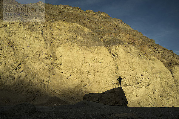 Silhouette eines Mannes  der auf dem Felsen gegen den Berg steht  Death Valley  Nevada  USA