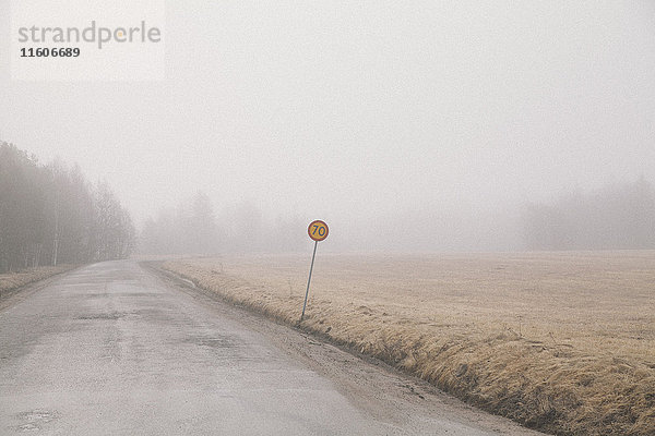 Landstraße für Feld bei Nebelwetter gegen den Himmel