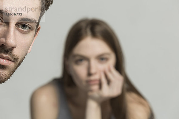 Porträt eines jungen Mannes mit einer Frau im Hintergrund