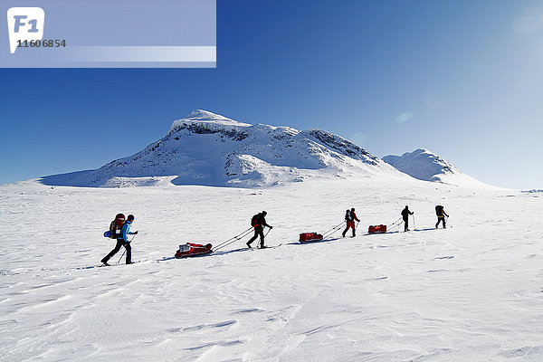 Touristen beim Skilanglauf vor Bergkulisse