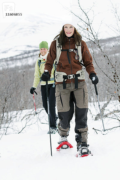 Lächelnde Frauen beim Schneeschuhwandern