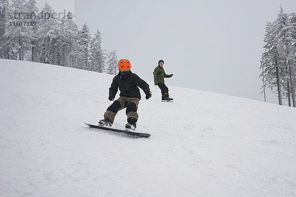 Boys Snowboarden auf der Piste