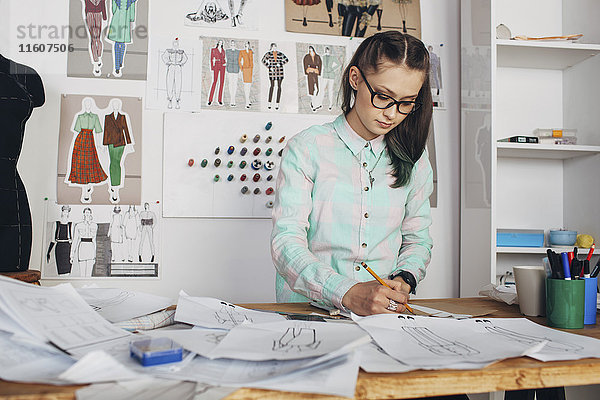 Schöne Modedesigner-Zeichnungsskizze an der Werkbank im Atelier