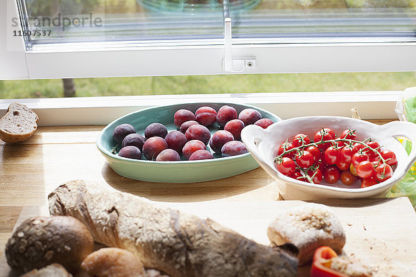 Nahaufnahme von Obst und Brot auf dem Tisch durch das Fenster