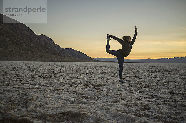 Volle Länge der jungen Frau beim Yoga in der Wüste bei Sonnenuntergang  Death Valley  Nevada  USA