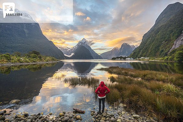 Tourist beim Betrachten der Landschaft  Miter Peak spiegelt sich im Wasser  Sonnenuntergang  Milford Sound  Fiordland National Park  Te Anau  Southland Region  Southland  Neuseeland  Ozeanien