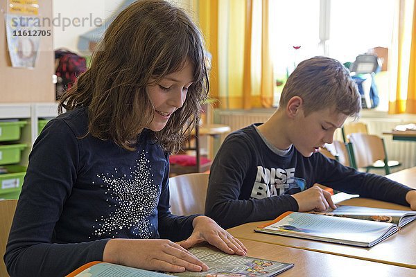 Schüler  Kinder lesen ein Buch  Deutschunterricht  Grundschule  Niedersachsen  Deutschland  Europa