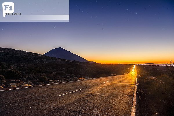 Lichtspuren vom Auto auf Bergstraße  Autobahn  Sonnenuntergang  Vulcano Teide im Gegenlicht  Silhouette  Vulkanlandschaft  Sternenhimmel  Nationalpark El Teide  Teneriffa  Kanarische Inseln  Spanien  Europa