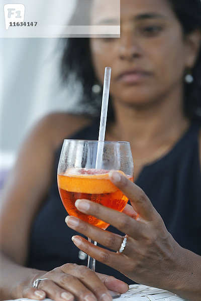 Frau trinkt einen Cocktail.