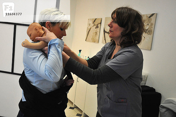 Reportage aus der Praxis einer freiberuflichen Hebamme in Ham in der Region Somme in Frankreich. Beratung zur physiologischen Lagerung beim Tragen des Babys.