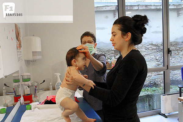 Reportage in einem französischen Mütter- und Kinderschutzzentrum in Châteaubriant  Frankreich. Konsultation eines Kinderarztes. Vermessung der Fontanelle.