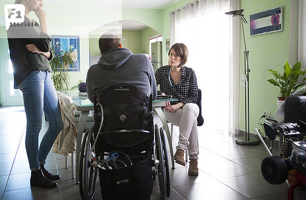 Reportage über einen häuslichen Pflegedienst in Savoie  Frankreich. Eine Krankenschwester und eine Hilfsschwester unterhalten sich mit einem Patienten.