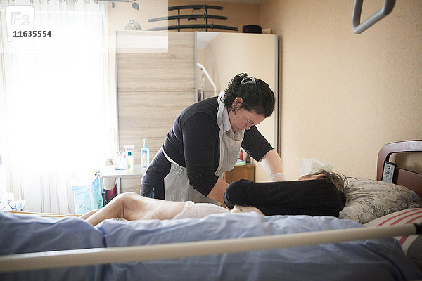 Reportage über einen häuslichen Pflegedienst in Savoie  Frankreich. Eine Hilfskraft pflegt einen Patienten am Ende seines Lebens.