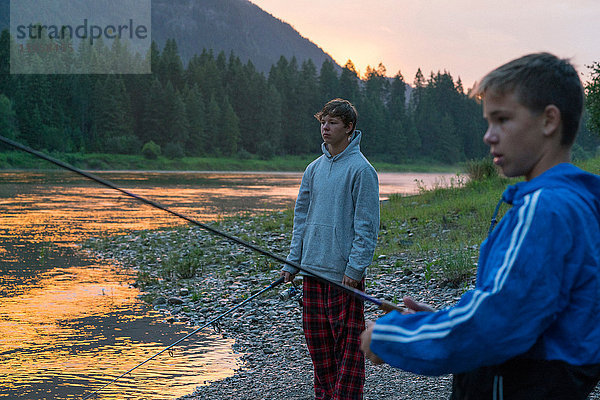 Teenager-Jungen beim Angeln im Fluss bei Sonnenuntergang  Washington  USA