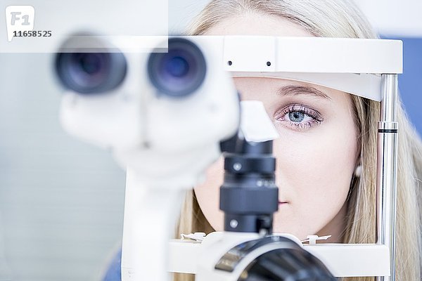 Weibliche Patientin bei einer Augenuntersuchung in einem Optikergeschäft  Nahaufnahme.