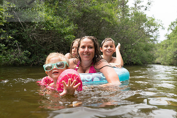 Mutter und Kinder mit aufblasbarem Ring im See  Niceville  Florida  USA