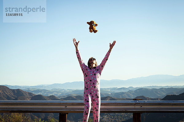 Mann in rosa Strampelhöschen wirft Teddybär in die Luft  Malibu Canyon  Kalifornien  USA