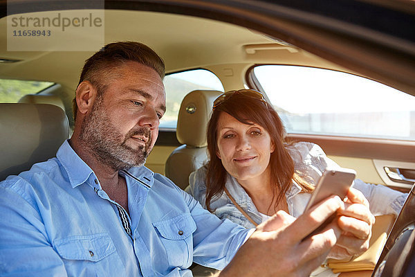 Ehepaar im Auto  Blick auf Smartphone
