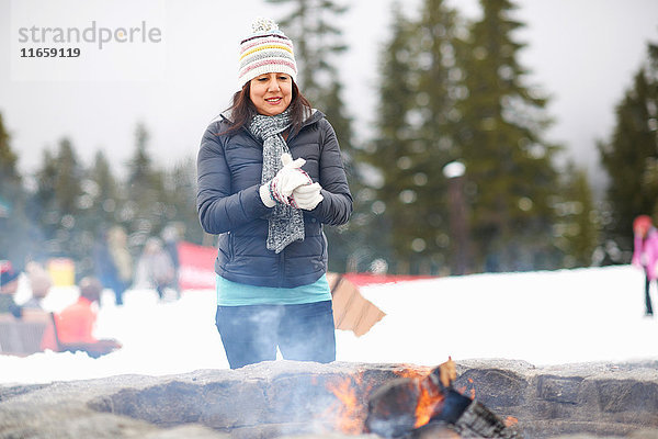 Frau wärmt sich an Feuergrube  Vancouver  Kanada